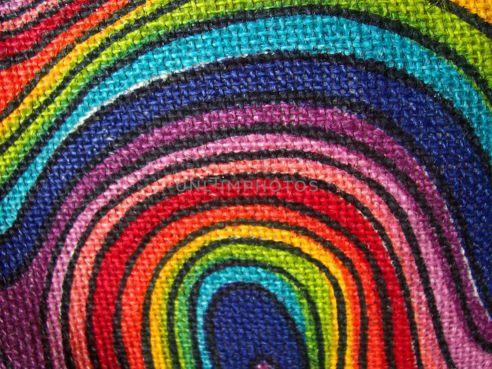 An abstract close-up photograph of a brightly coloured fabric with swirls.