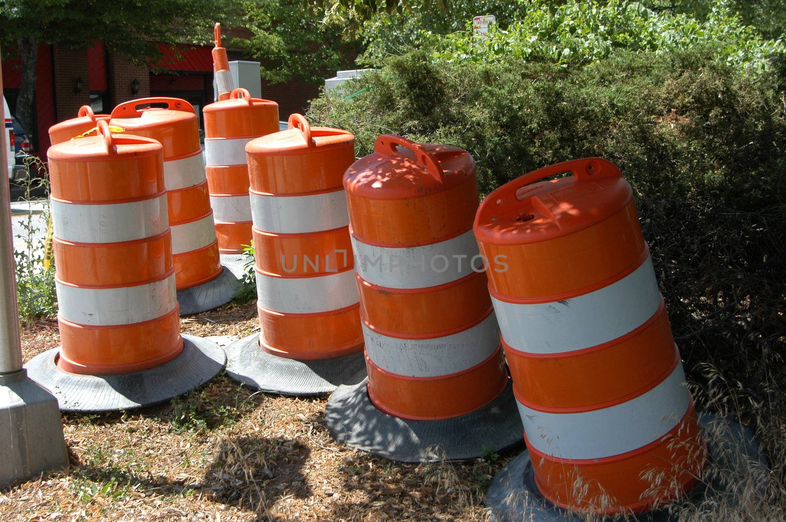 Orange and white traffic barrels ready for use in the city