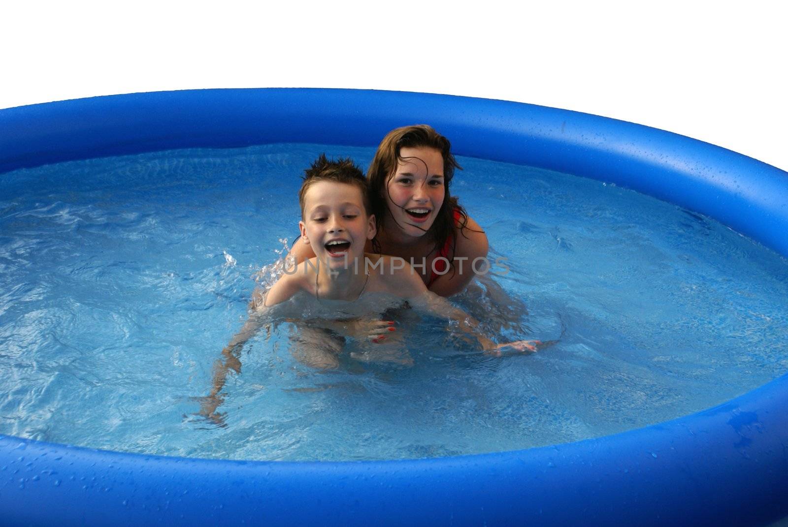 Two kids having fun in a swimming pool.