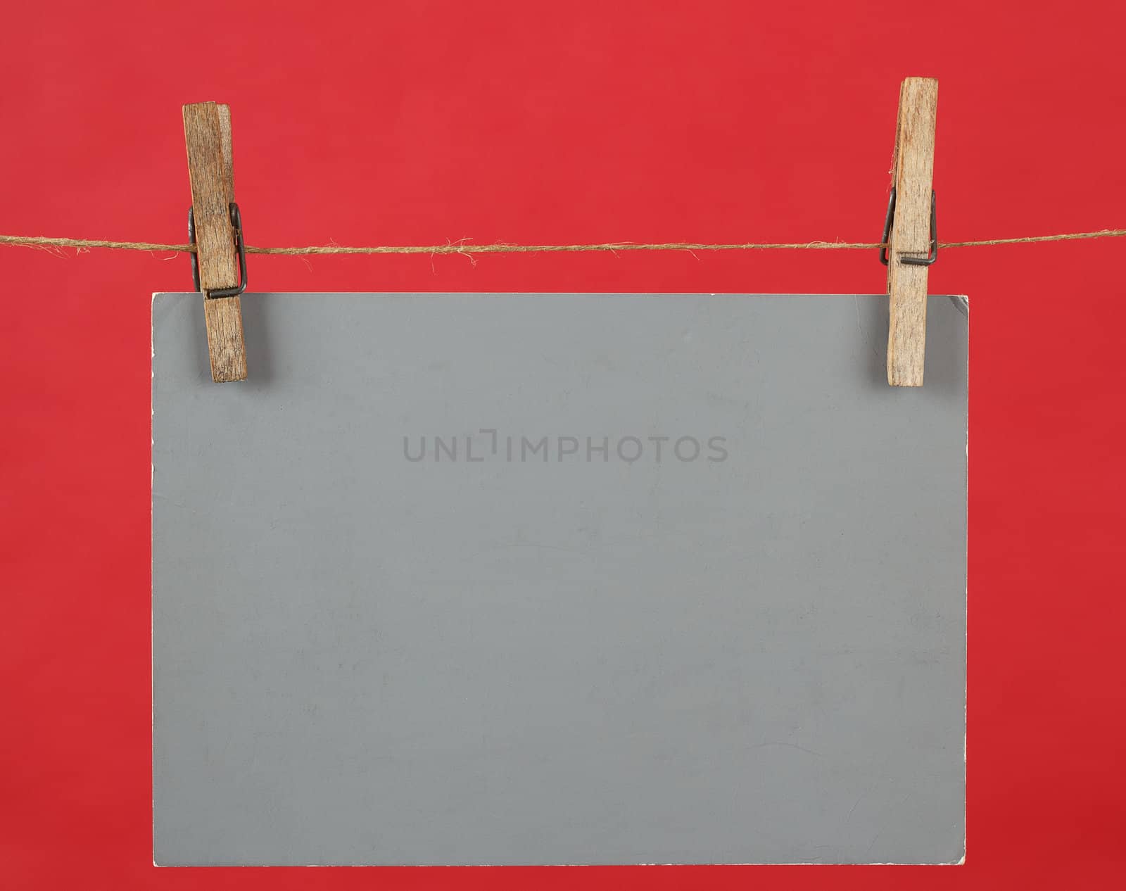 Memory note grey paper hanging on cord on red background