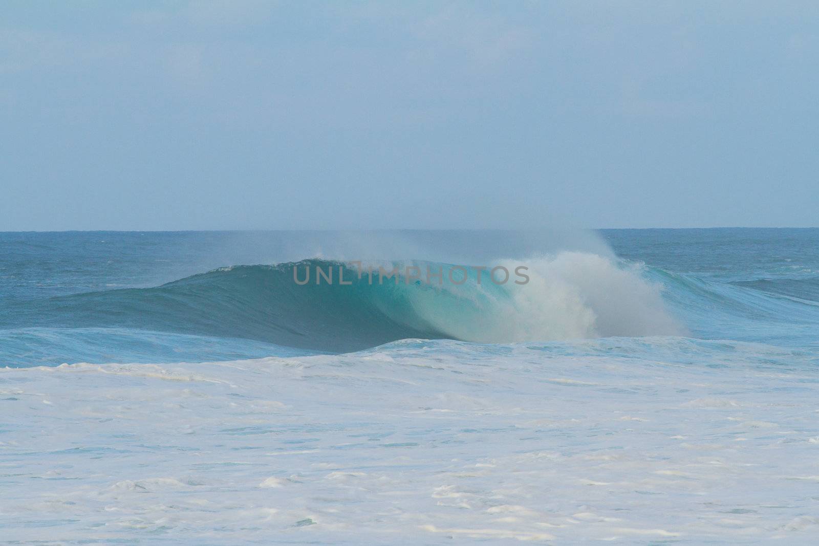 These huge waves with hollow barrels break off the north shore of Oahu in Hawaii during a big storm. These dangerous waves have major rip currents and a lot of power from the ocean but surfers are still lining up to surf.