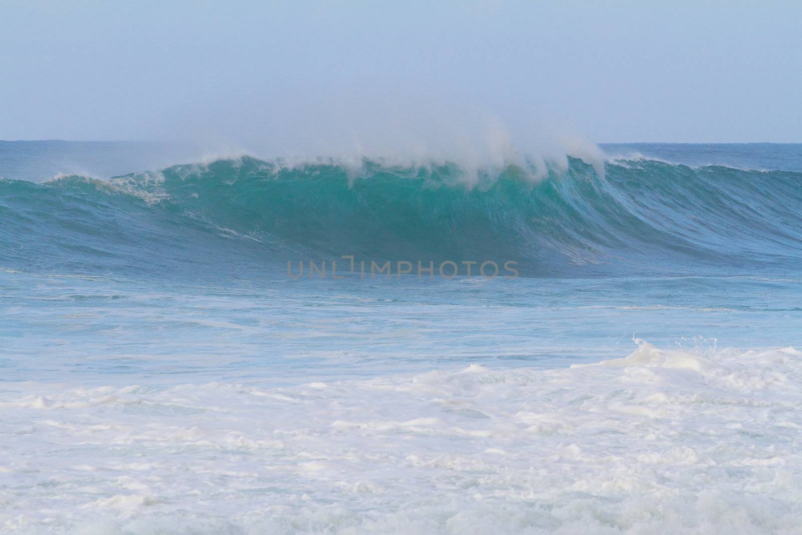 These huge waves with hollow barrels break off the north shore of Oahu in Hawaii during a big storm. These dangerous waves have major rip currents and a lot of power from the ocean but surfers are still lining up to surf.