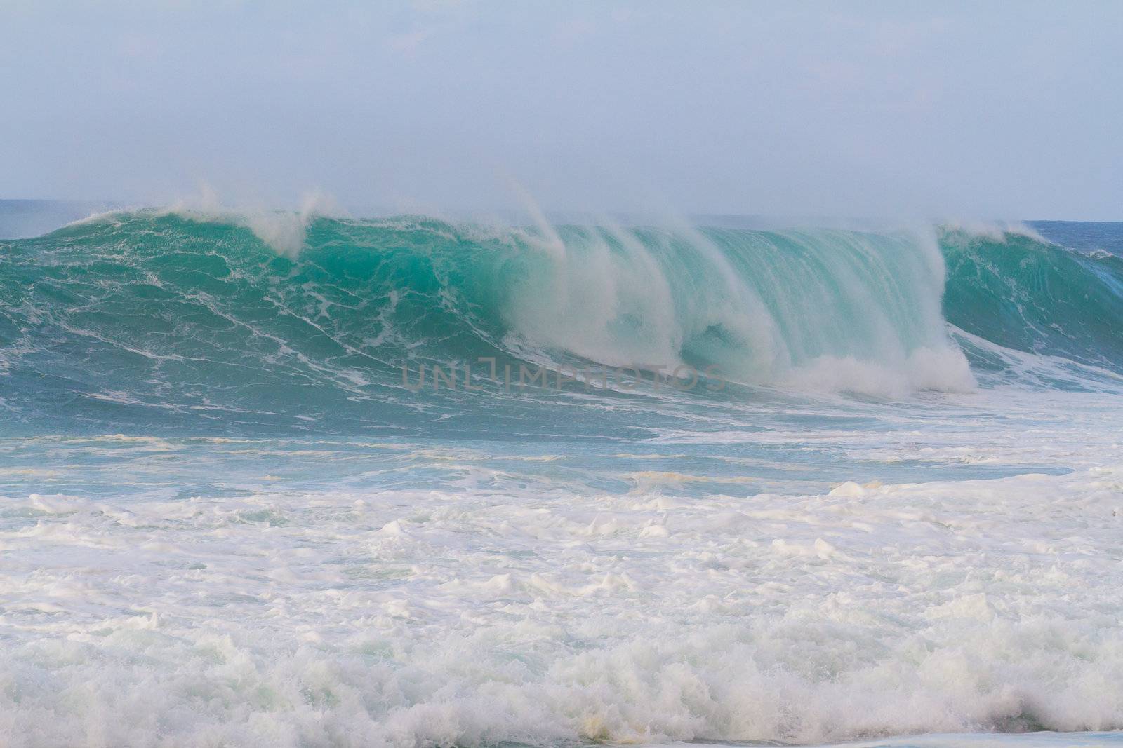 These huge waves with hollow barrels break off the north shore of Oahu in Hawaii during a big storm. These dangerous waves have major rip currents and a lot of power from the ocean but surfers are still lining up to surf.