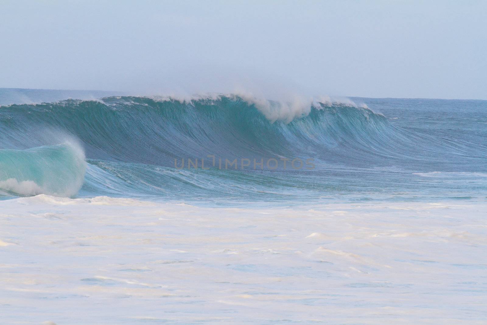 These huge waves with hollow barrels break off the north shore of Oahu in Hawaii during a big storm. These dangerous waves have major rip currents and a lot of power from the ocean but surfers are still lining up to surf.