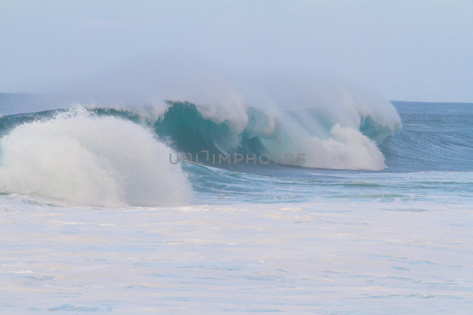 These huge waves with hollow barrels break off the north shore of Oahu in Hawaii during a big storm. These dangerous waves have major rip currents and a lot of power from the ocean but surfers are still lining up to surf.