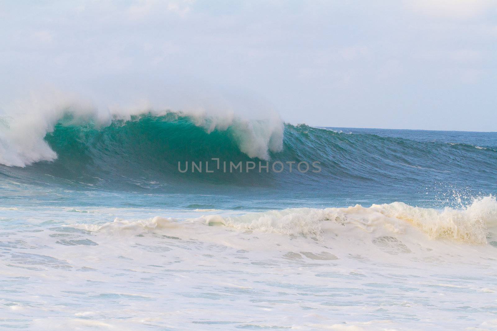 These huge waves with hollow barrels break off the north shore of Oahu in Hawaii during a big storm. These dangerous waves have major rip currents and a lot of power from the ocean but surfers are still lining up to surf.
