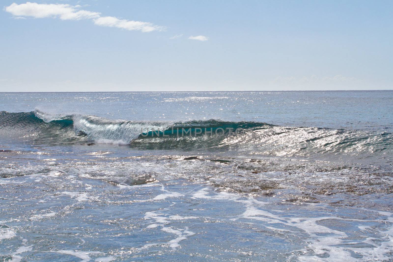 These almost completely clear waves are swelling and breaking onto some rocks on Oahu Hawaii. These waves are interesting and different than most.