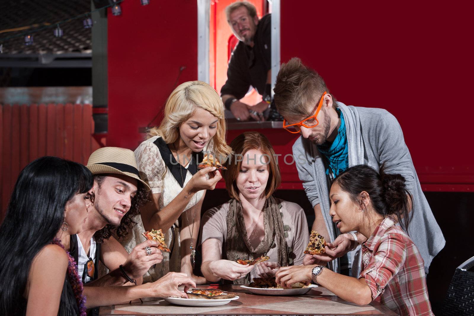 Mixed group of hipsters with pizza at food truck