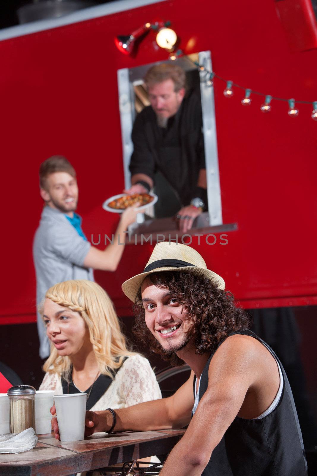 Caucasian male at table with friends ordering pizza