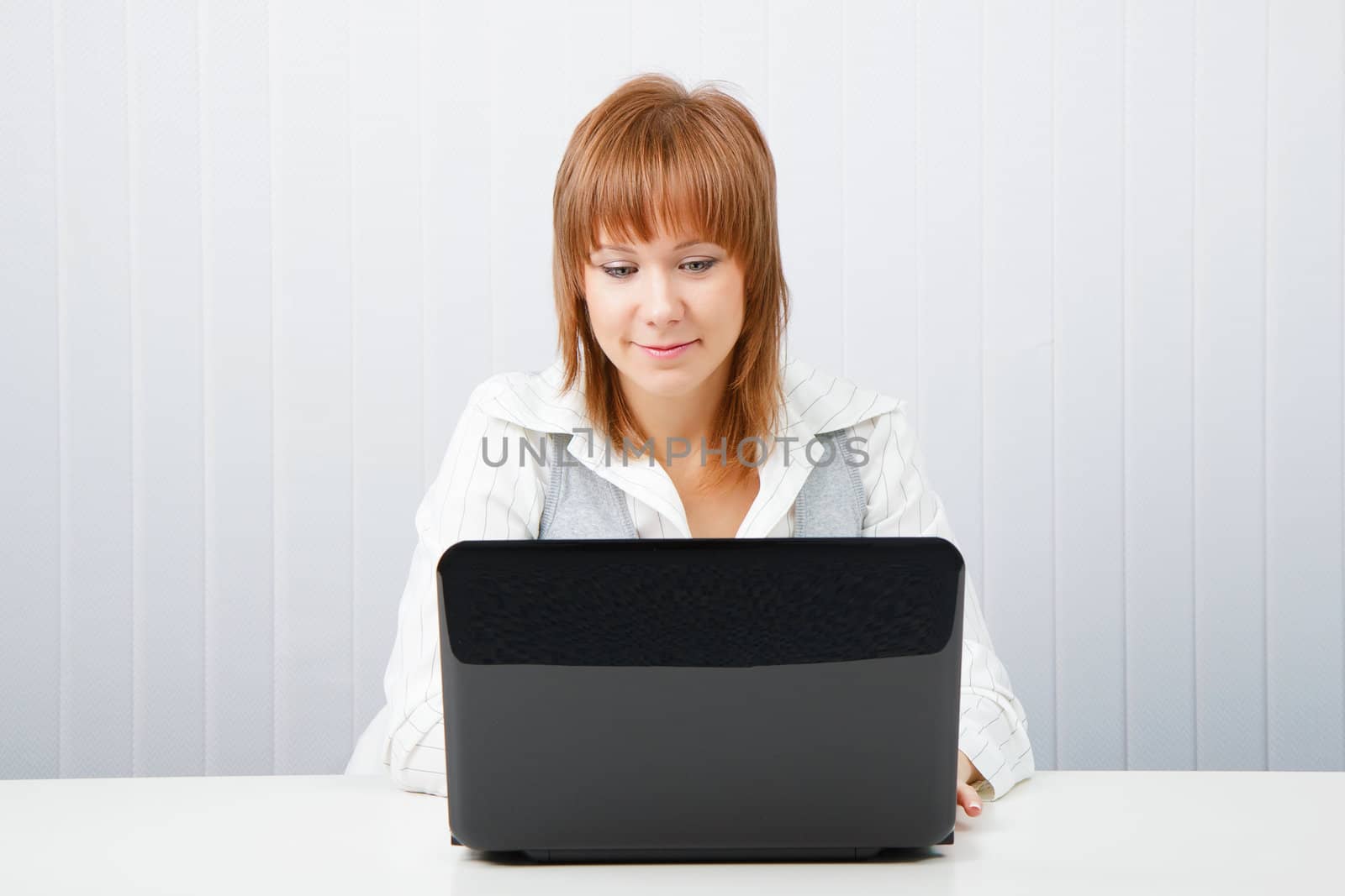 Attractive girl with a laptop in the office