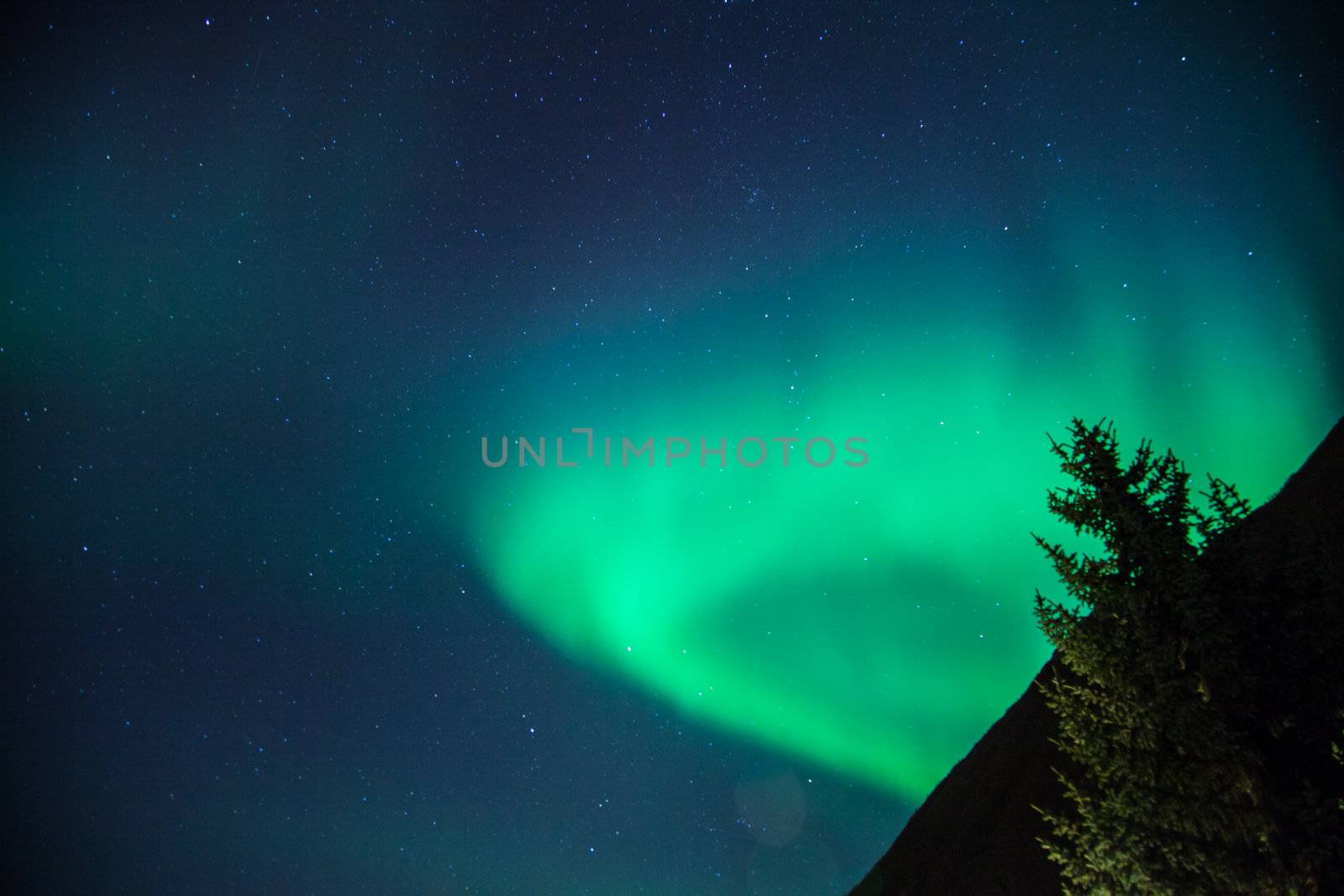 Northern lights arise over a mountain