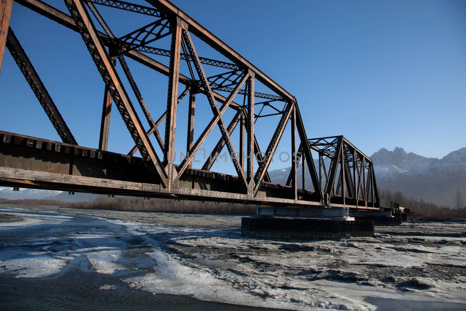 Railroad bridge crosses a freezing river  in Alaska
