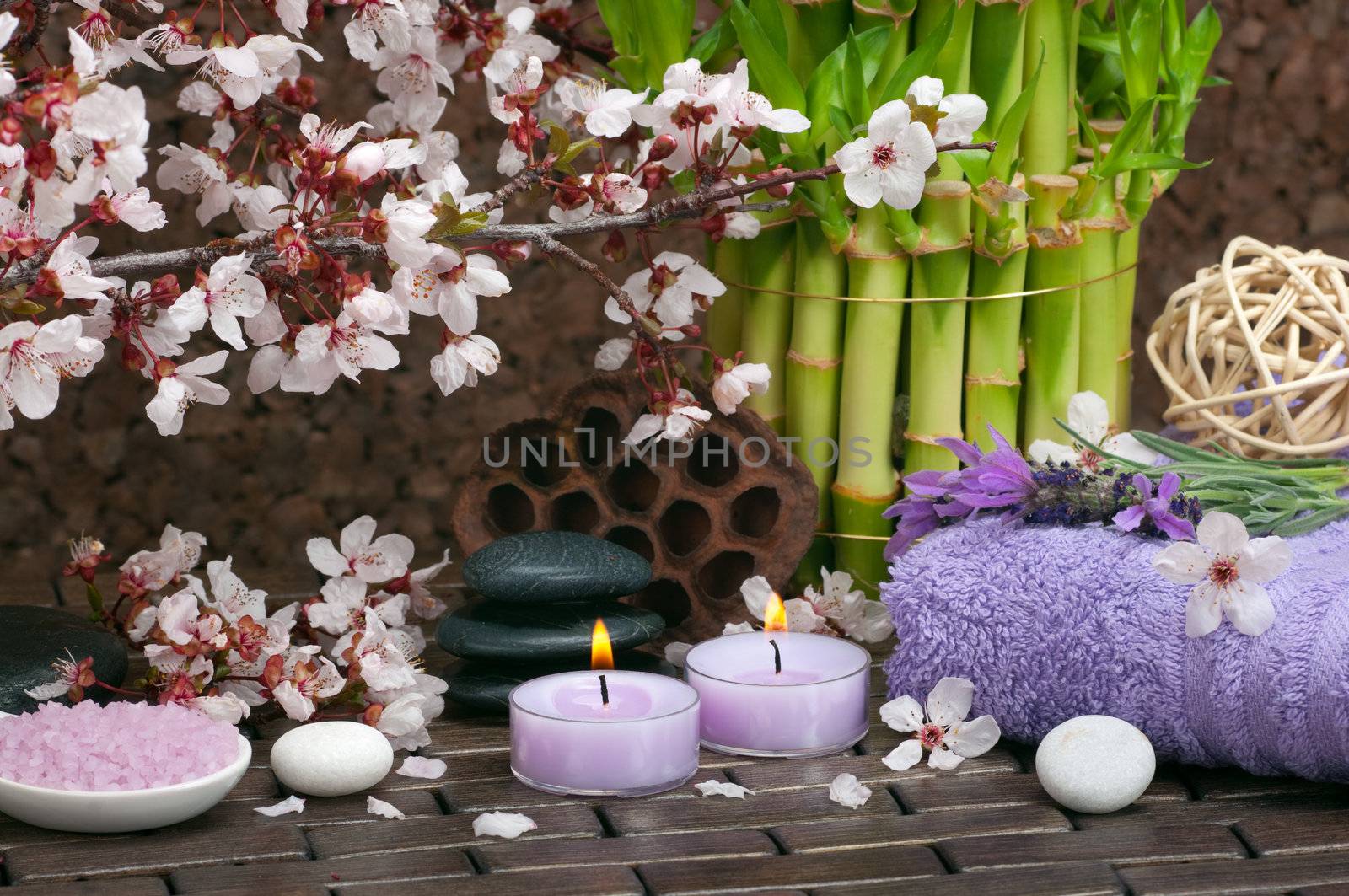 Spa concept with aromatic candles, lavender, bath salts, healing pebbles, cotton towels