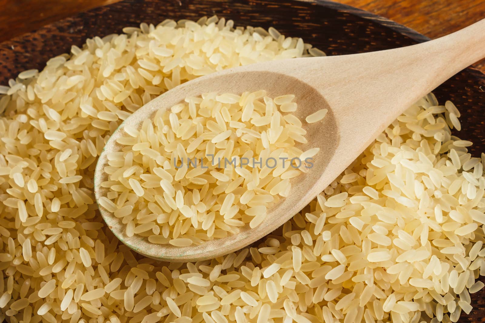 Rice on the plate with a wooden spoon