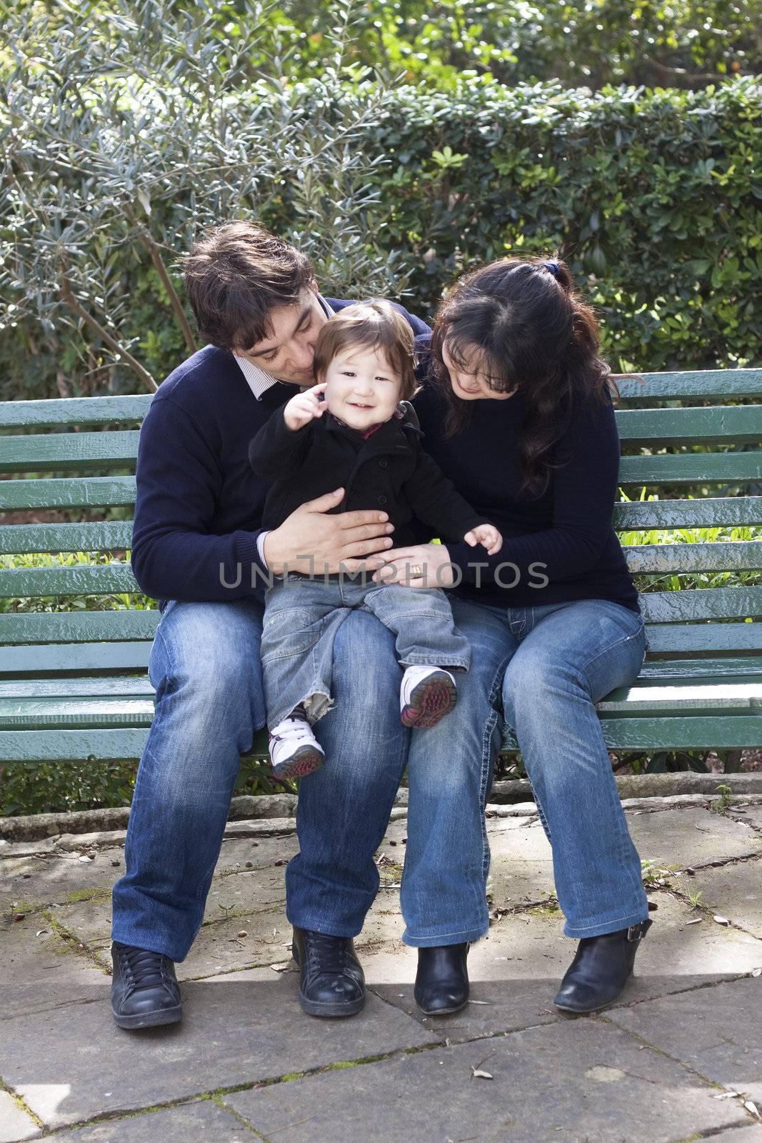 Asian mother caucasian father and child on a parkbench by annems