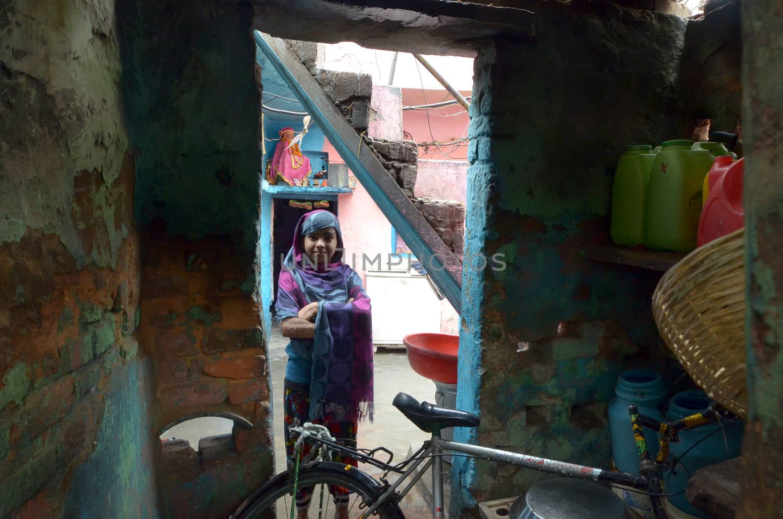 New Delhi,India-February 4, 2013: A woman in the courtyard of his house located in the slums of New Delhi. In India, greatly increases the number of the poor people living in slums