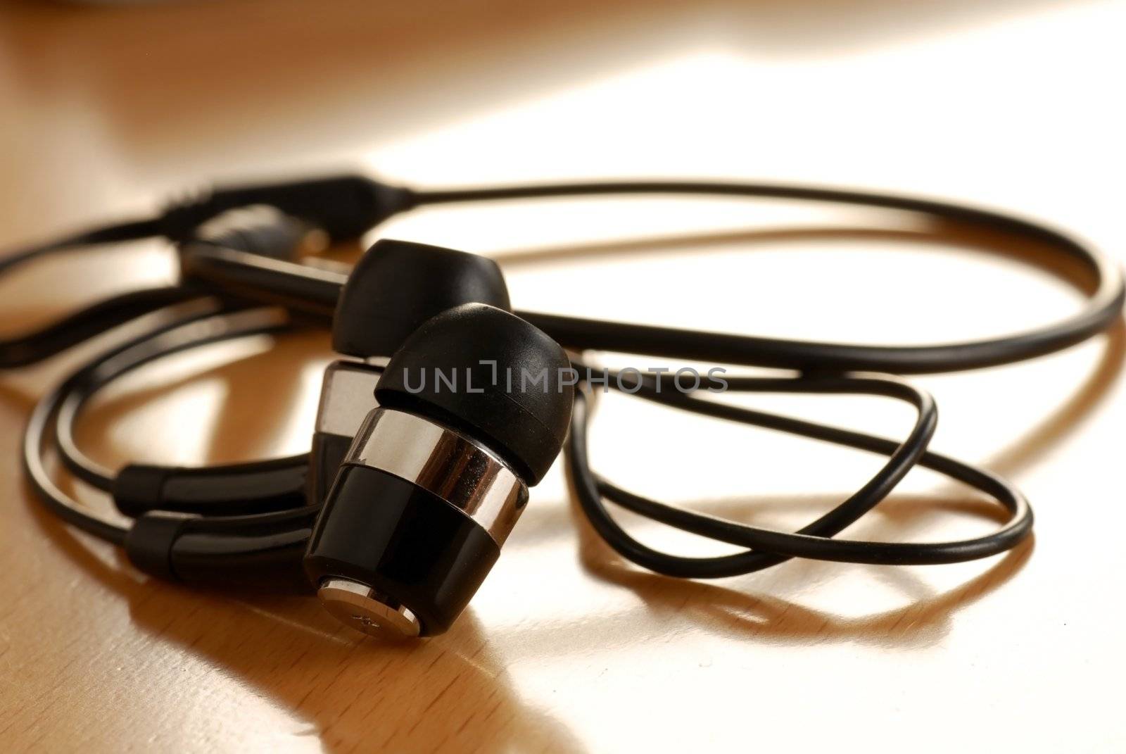 black unplugged ear buds on desk macro closeup