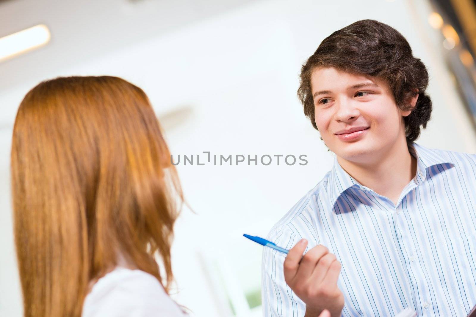 Attractive young man and woman sitting on the floor talking