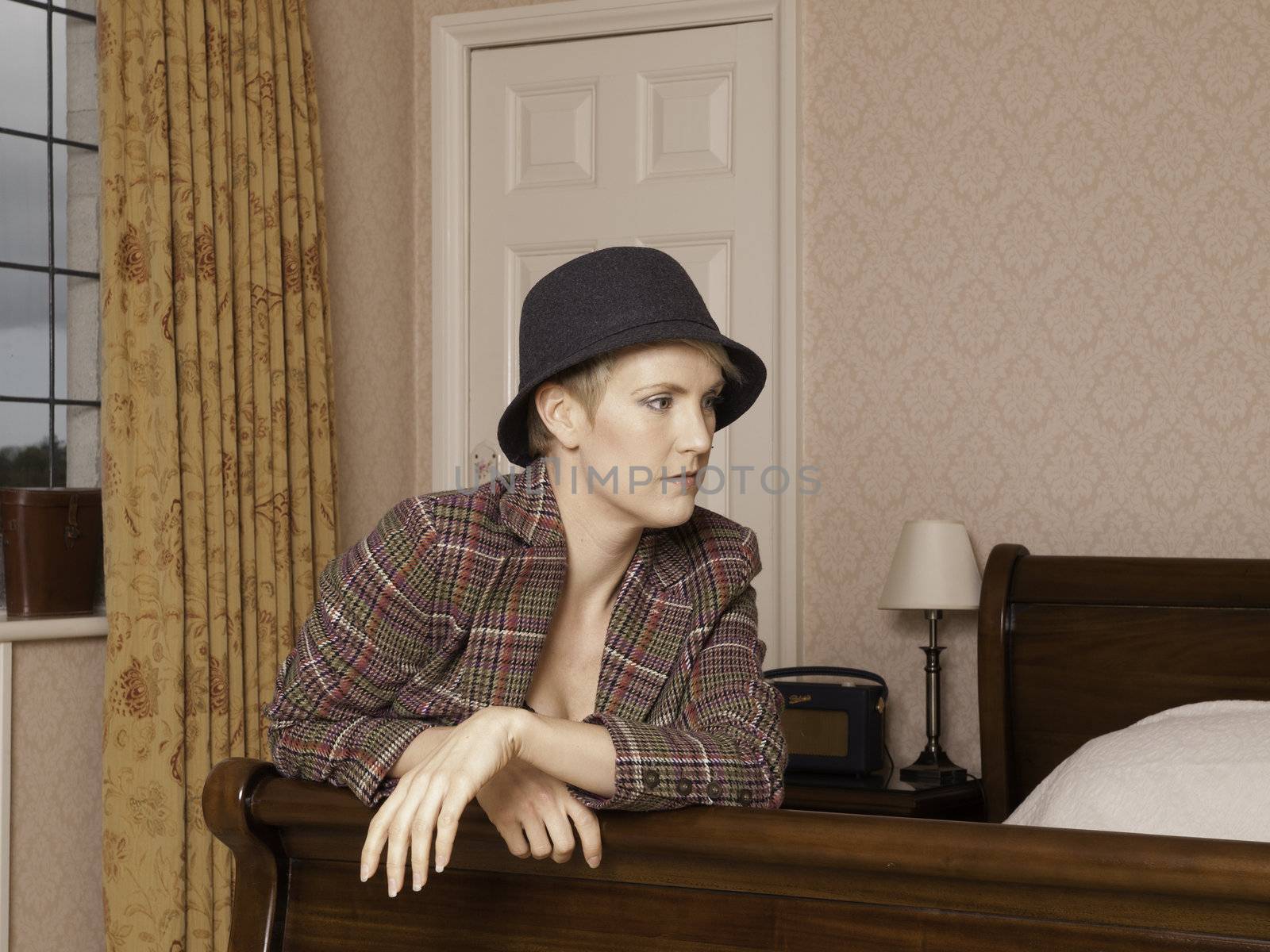 Woman wearing lingerie with a tweed jacket and hat