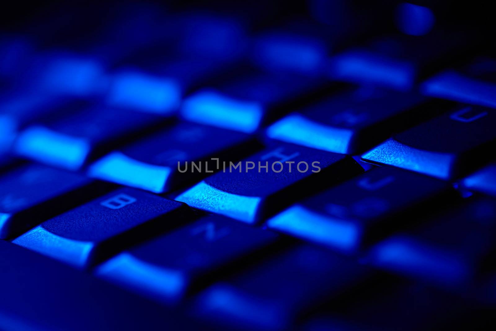 Computer keyboard in blue light. Small depth of field.