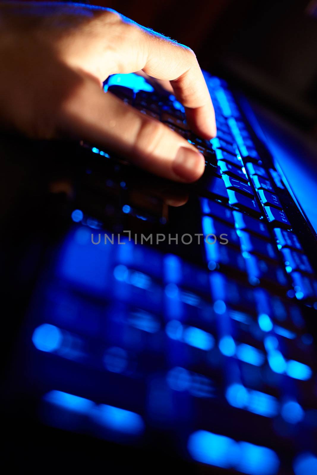 Beautiful business concepts. Man's hand typing on a blue keyboard. Vertical shot.