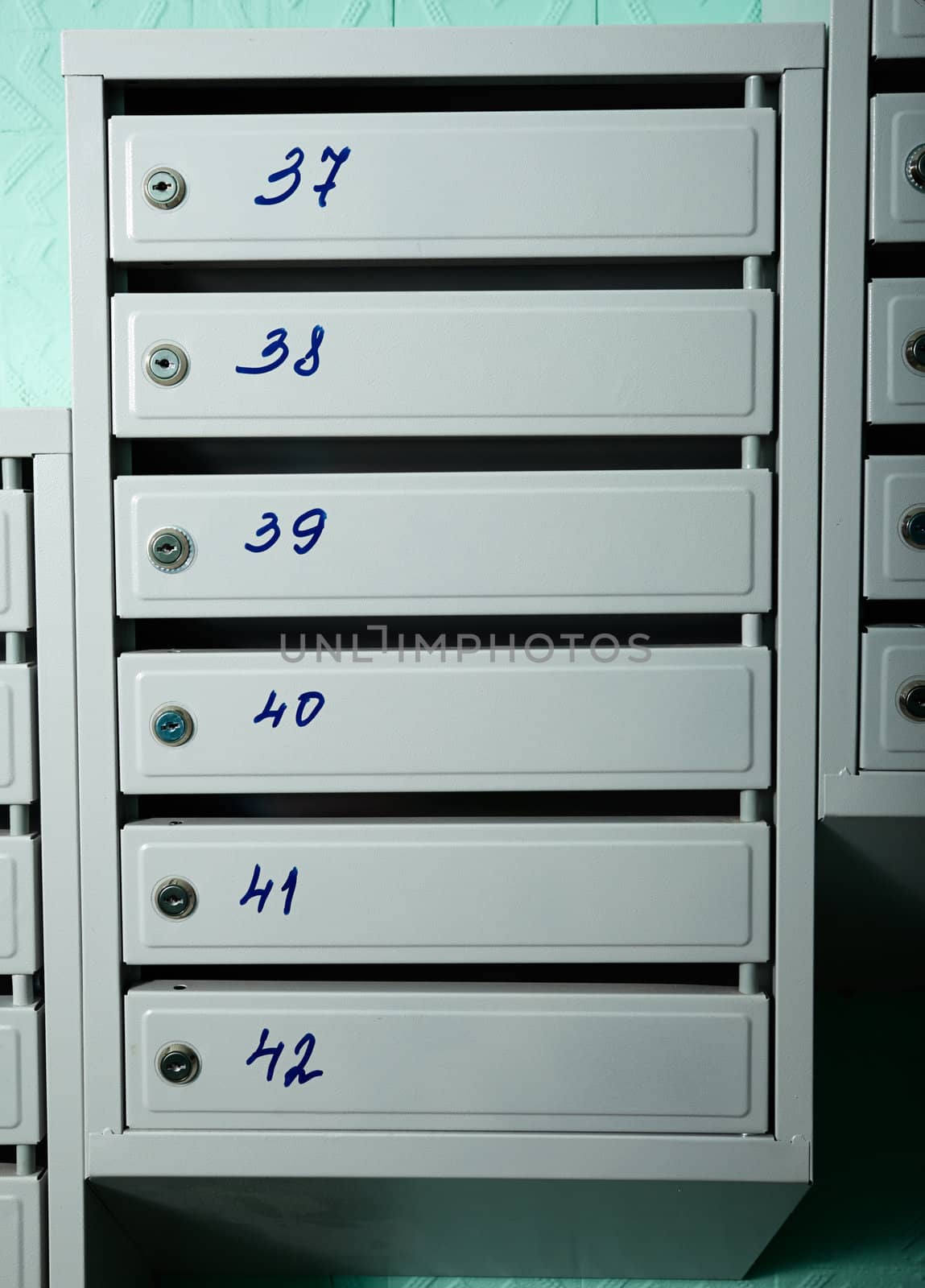 Gray blue metallic mailboxes with flat numbers.