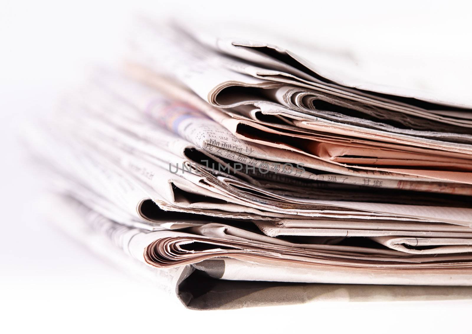 International newspapers on white background. Beautiful shallow dof.