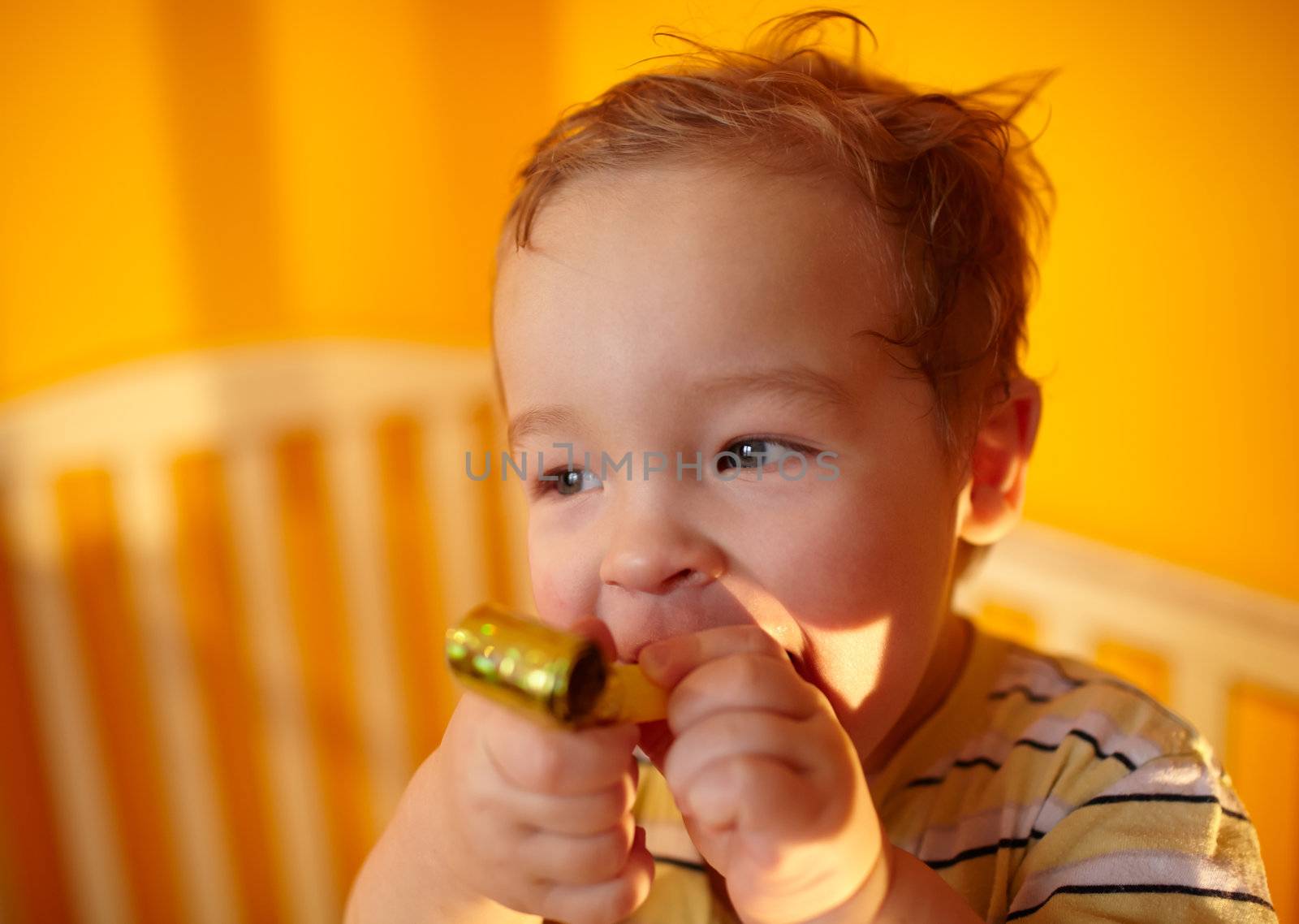 Portrait of the smiling boy playing in the playpen.