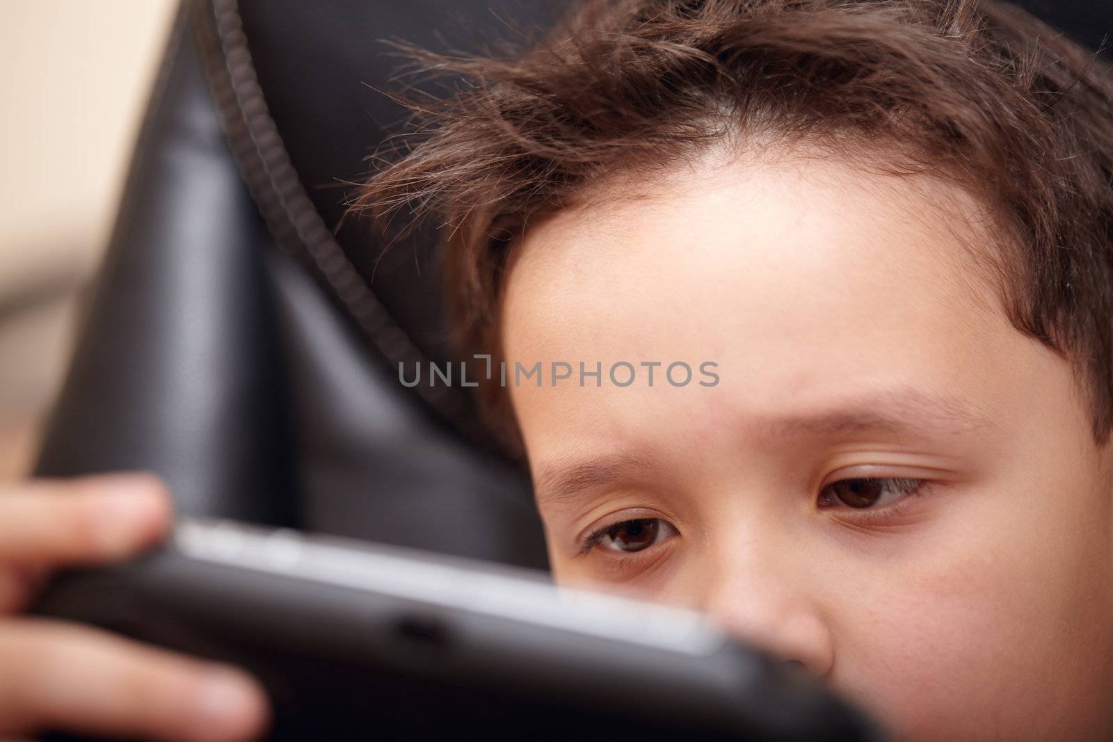 Boy tired of playing his portable game console.