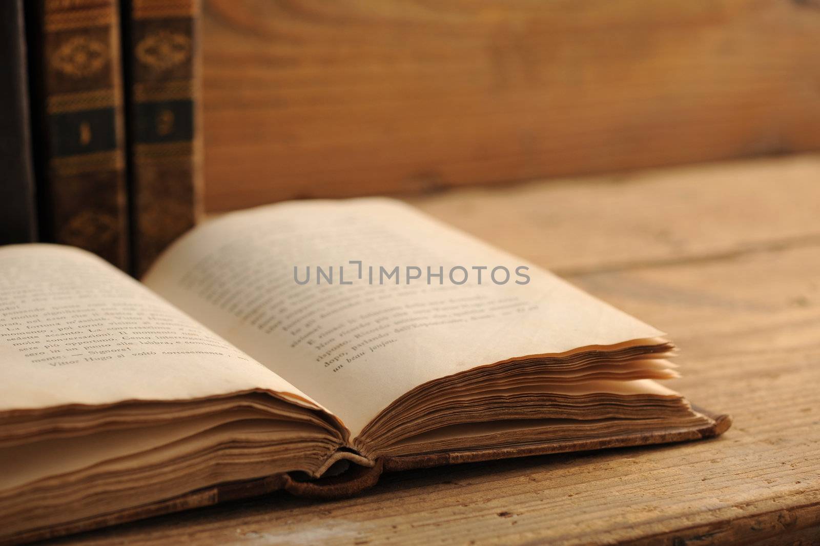 old book open on a wooden table by stokkete