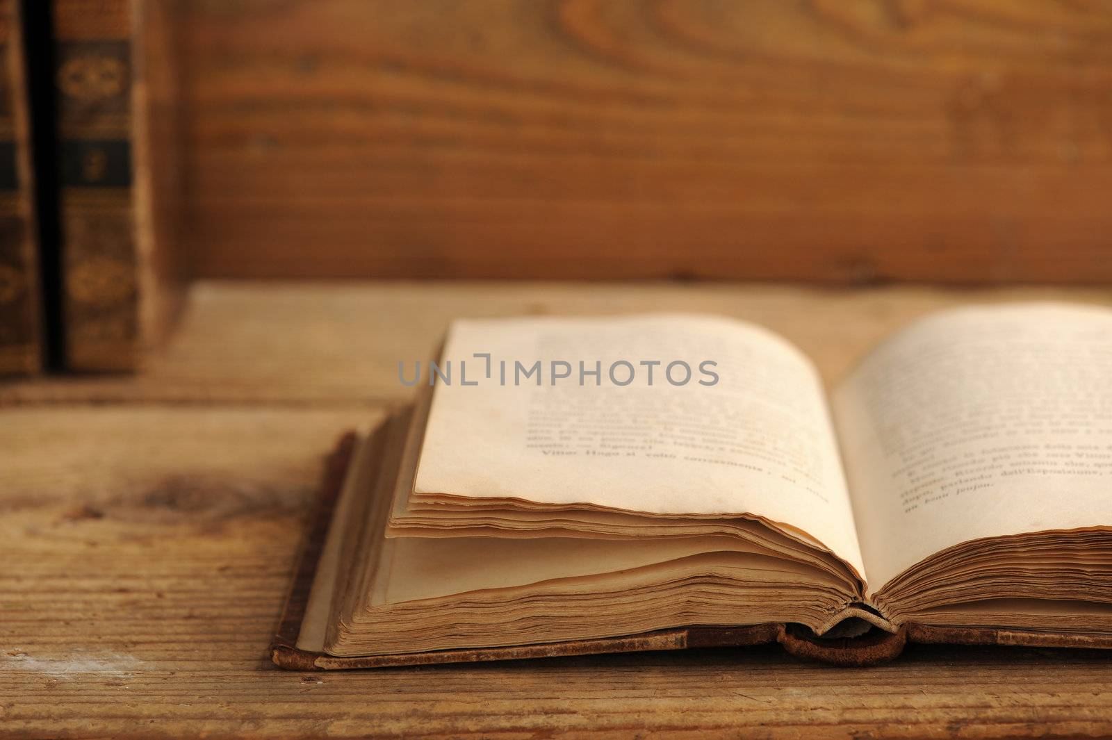 old book open on a wooden table by stokkete