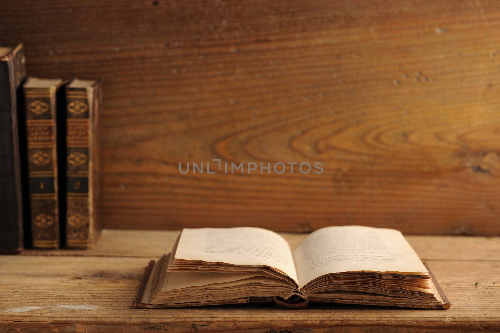 old book open on a wooden table by stokkete