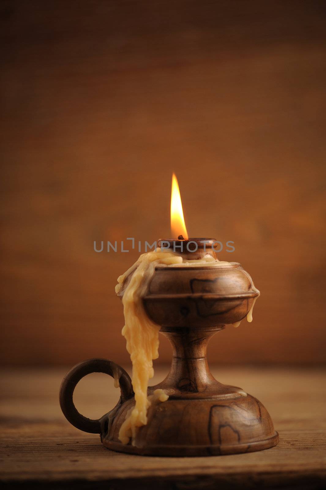 old candle on a wooden table by stokkete