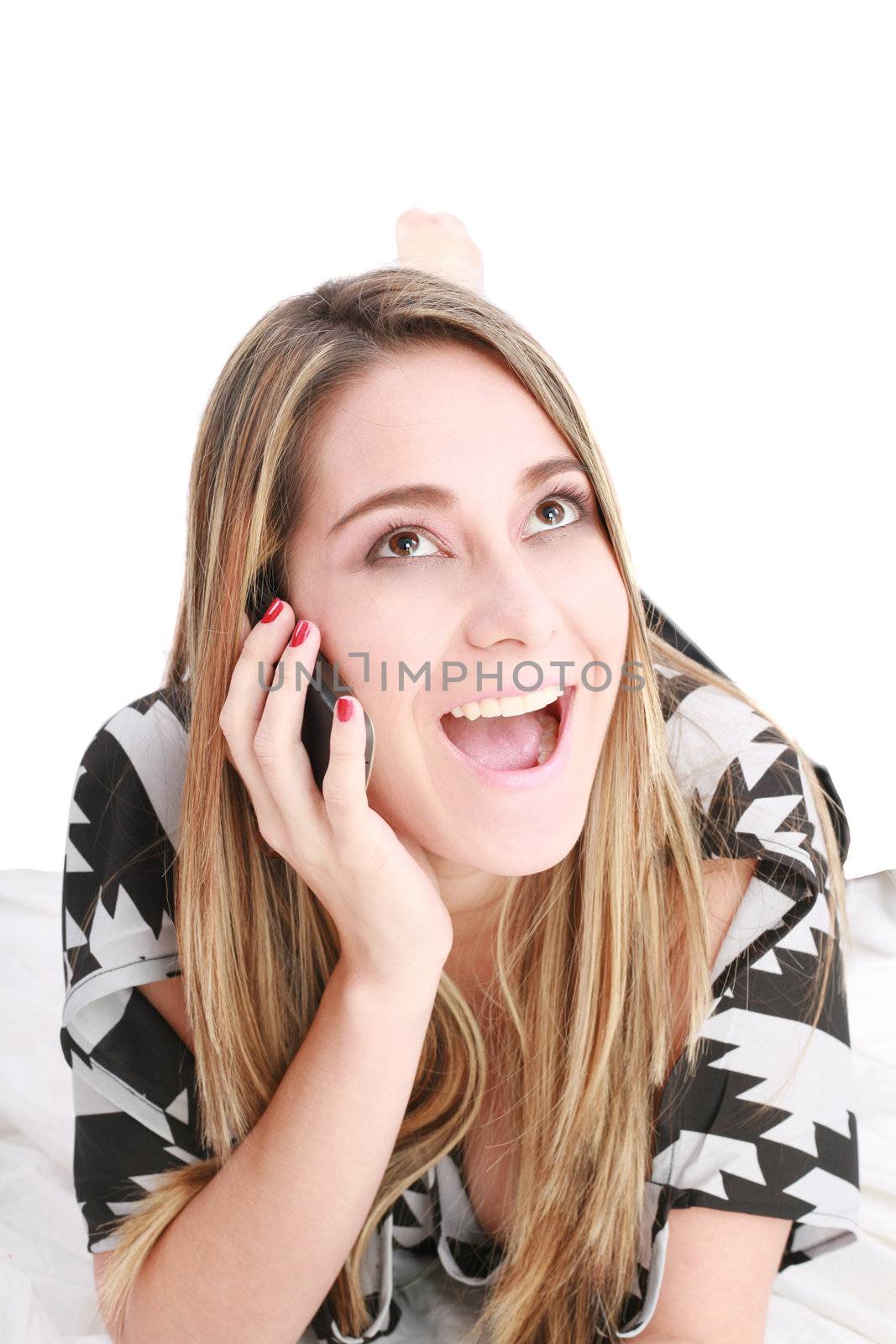 Beautiful happy blond woman talking on cell phone lying down on by dacasdo