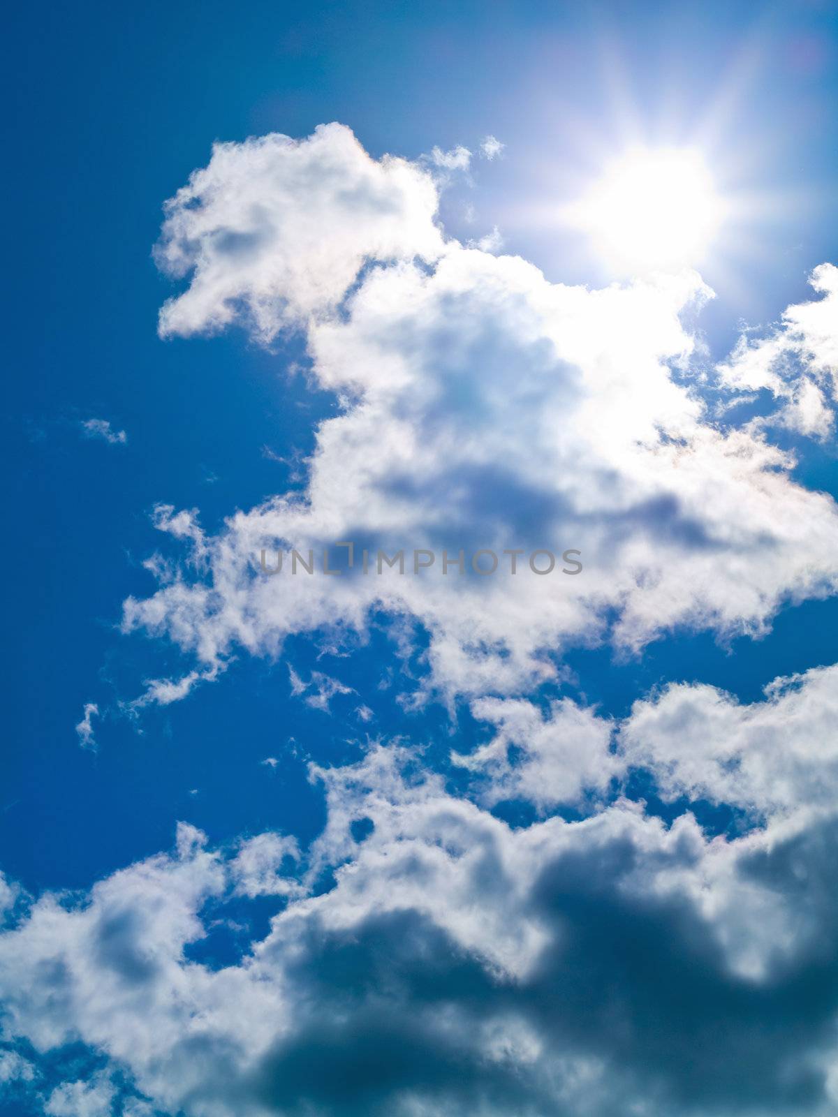 Sun in the sky with white clouds