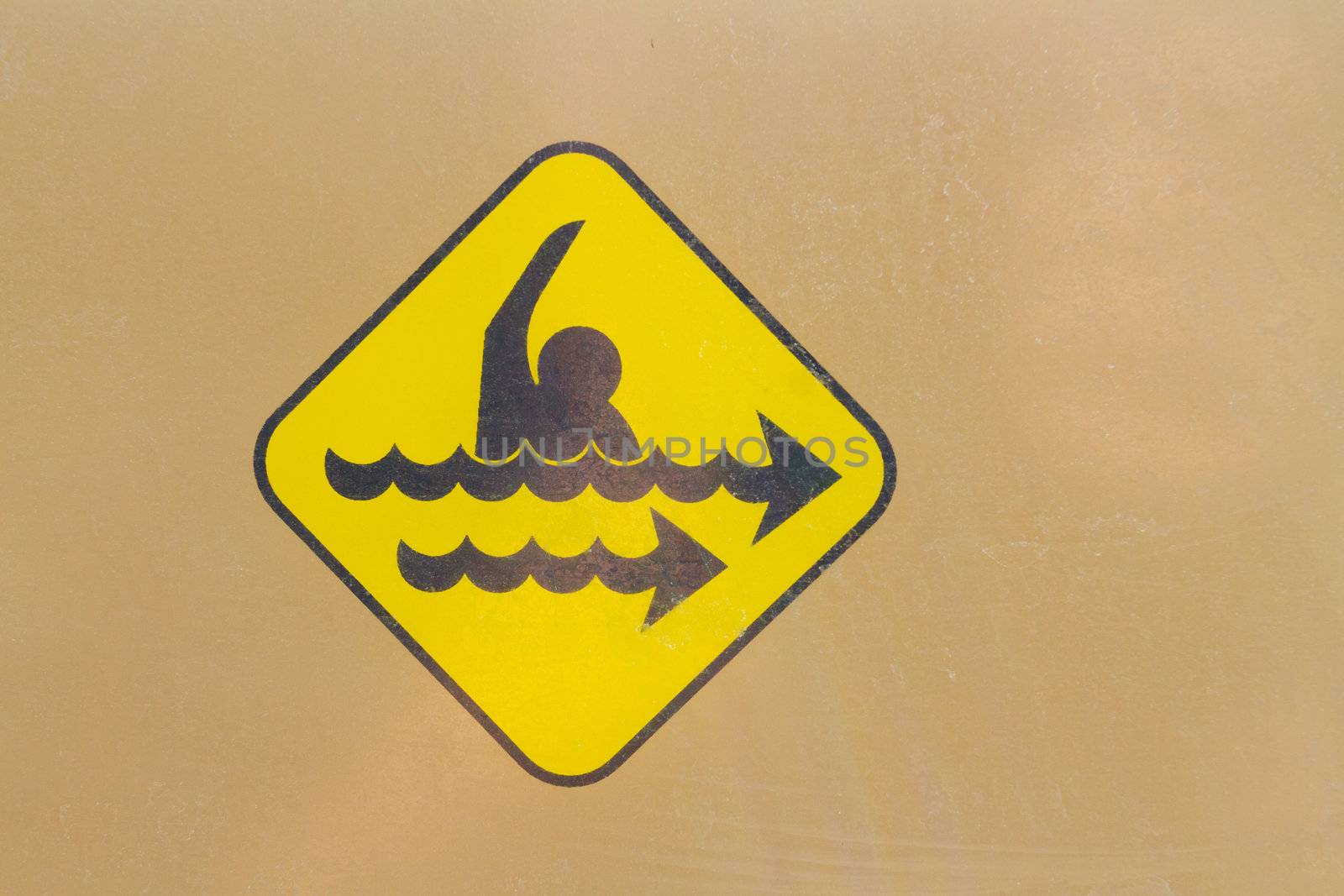 A warning sign icon shows the danger of a strong rip current. This yellow hazard sign is universal.