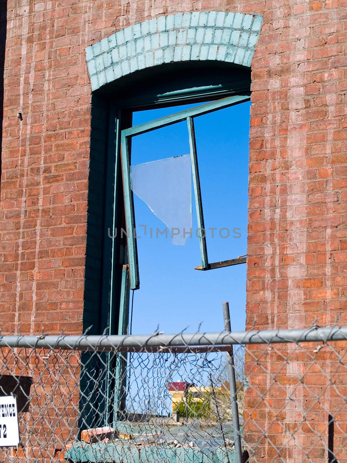 Brick wall and broken window at a demolition site