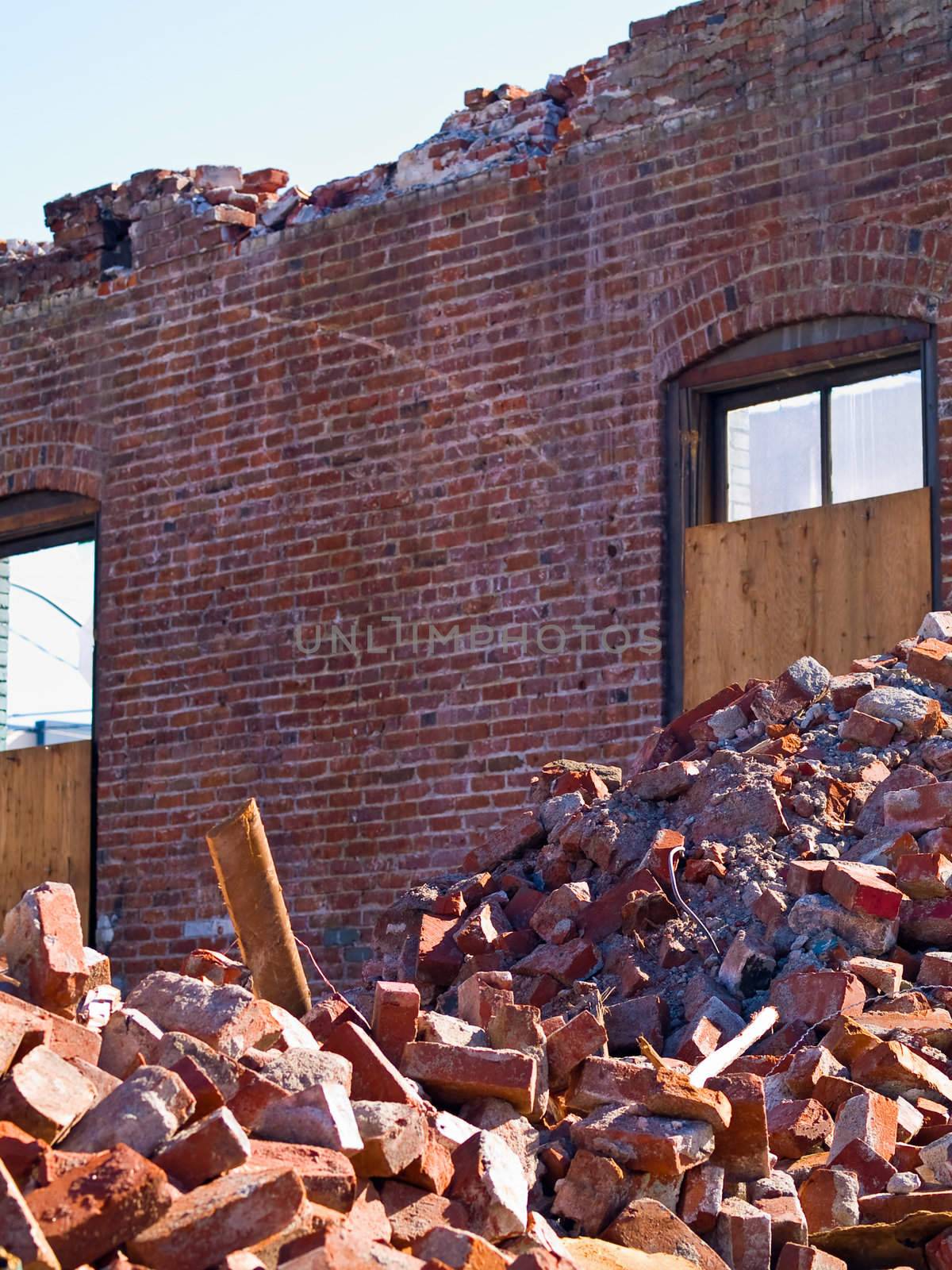 A demolition site with a pile of demolished brick wall and concrete debris