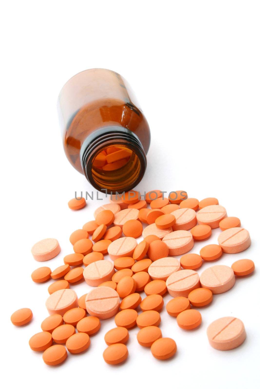 Open pill bottle with medicine spilling out of it isolated on white