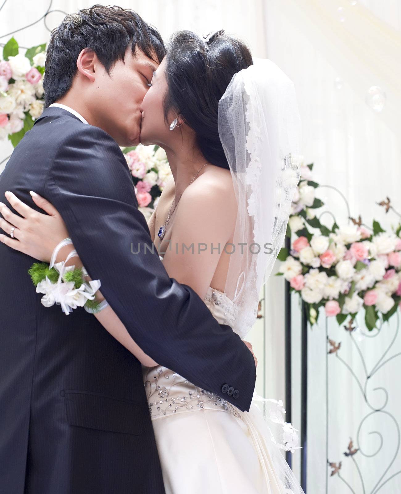a young couple embracing and kissing on their wedding day