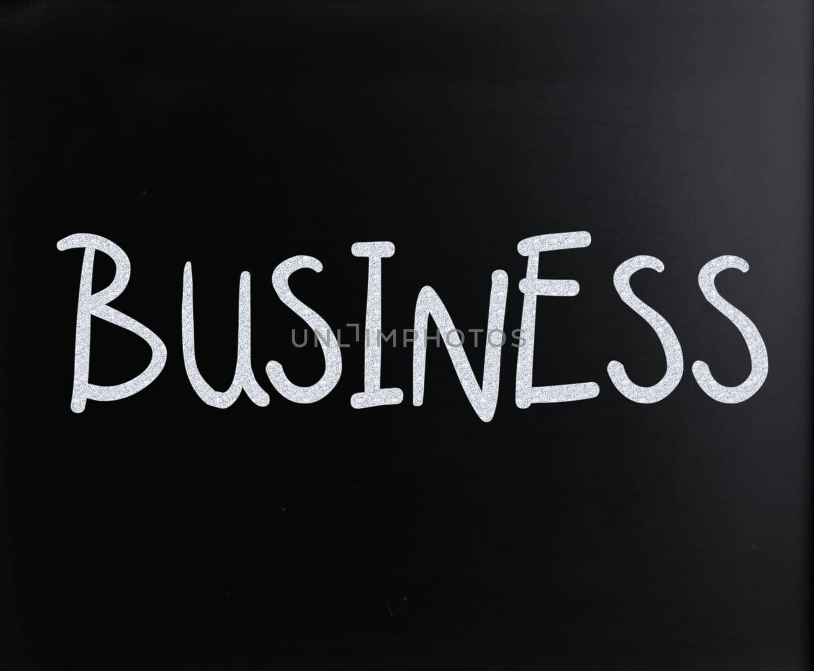 The word "Business" handwritten with white chalk on a blackboard