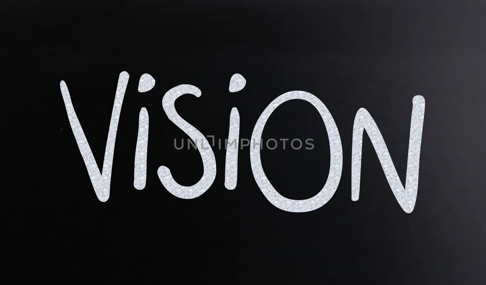 The word "Vision" handwritten with white chalk on a blackboard