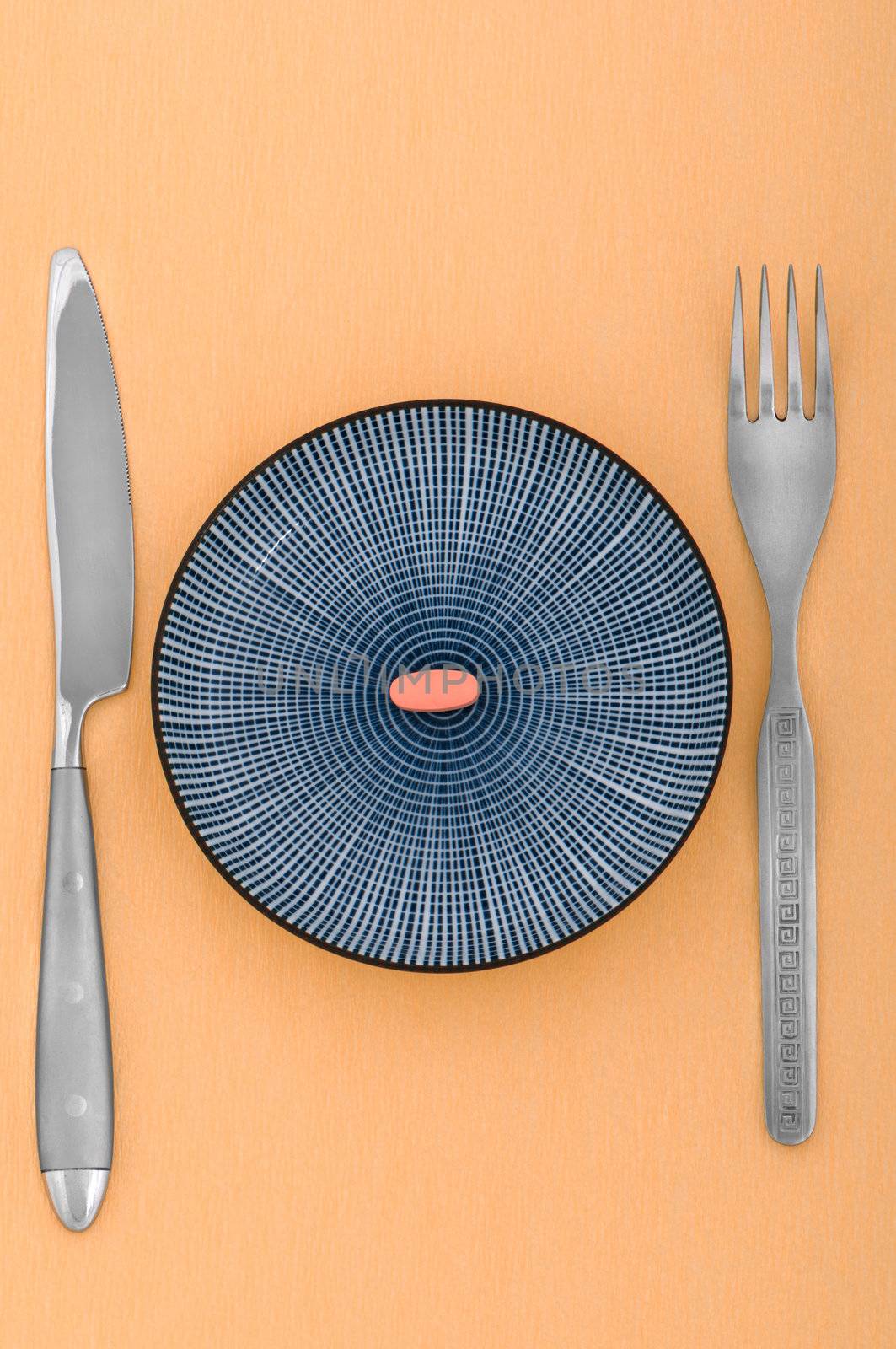 Single pill served on a saucer with knife and a fork