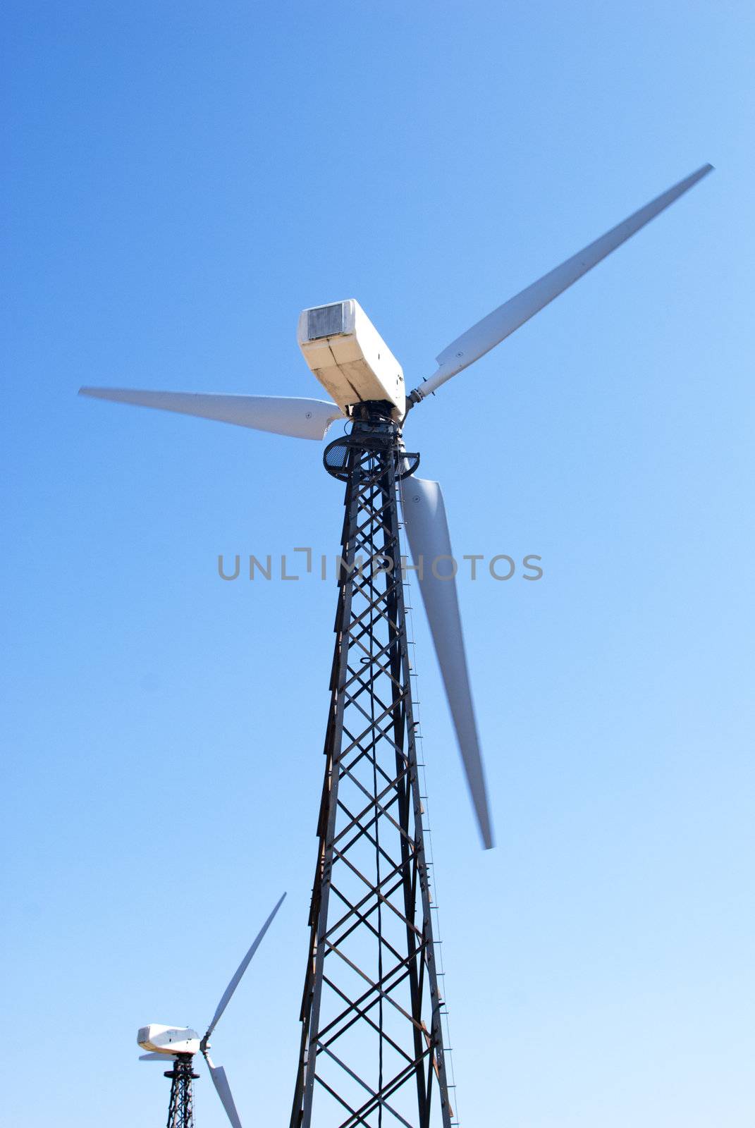 wind energy, modern white wind turbine in motion producing energy to power a city
