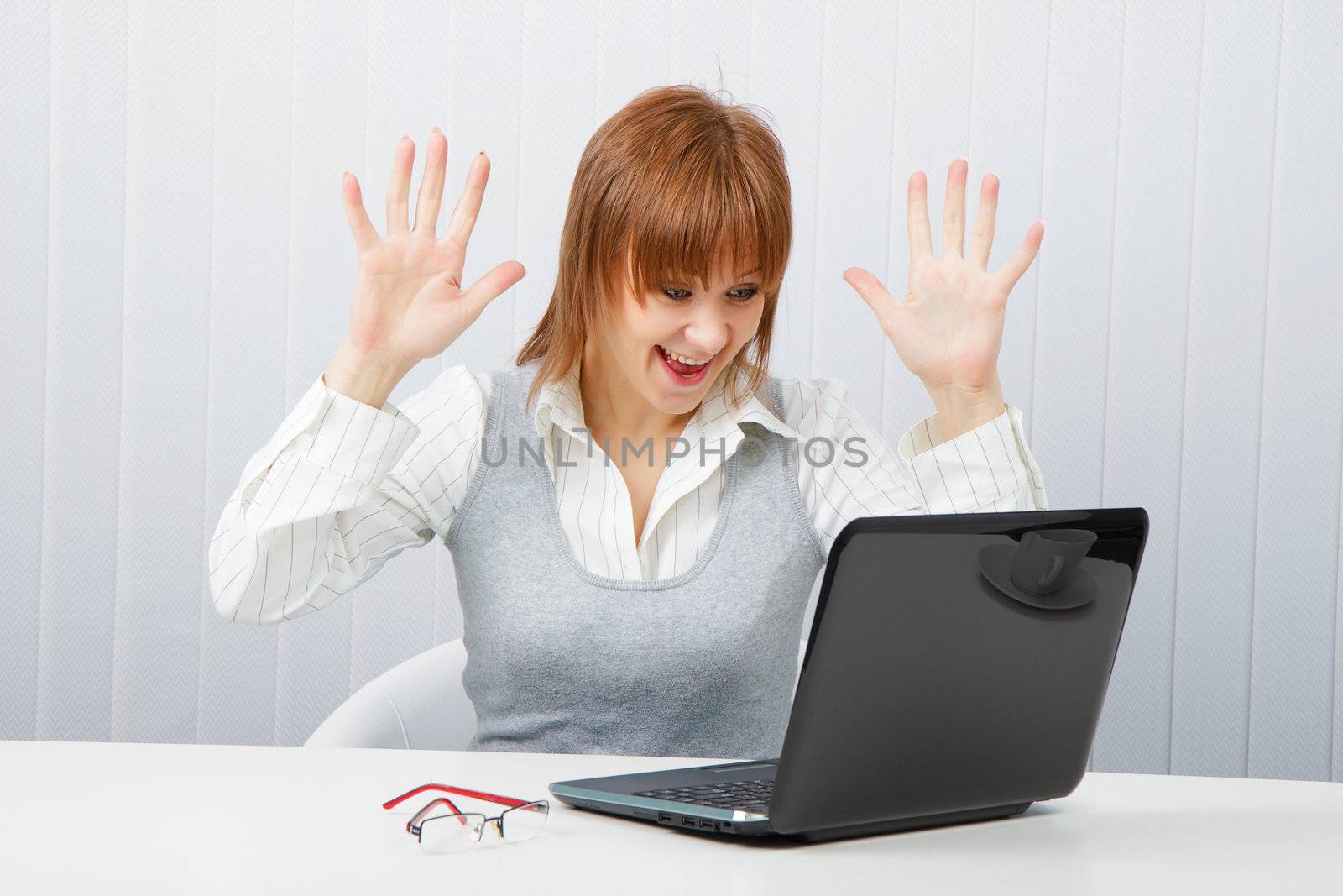 Delighted girl looks at a monitor. Office