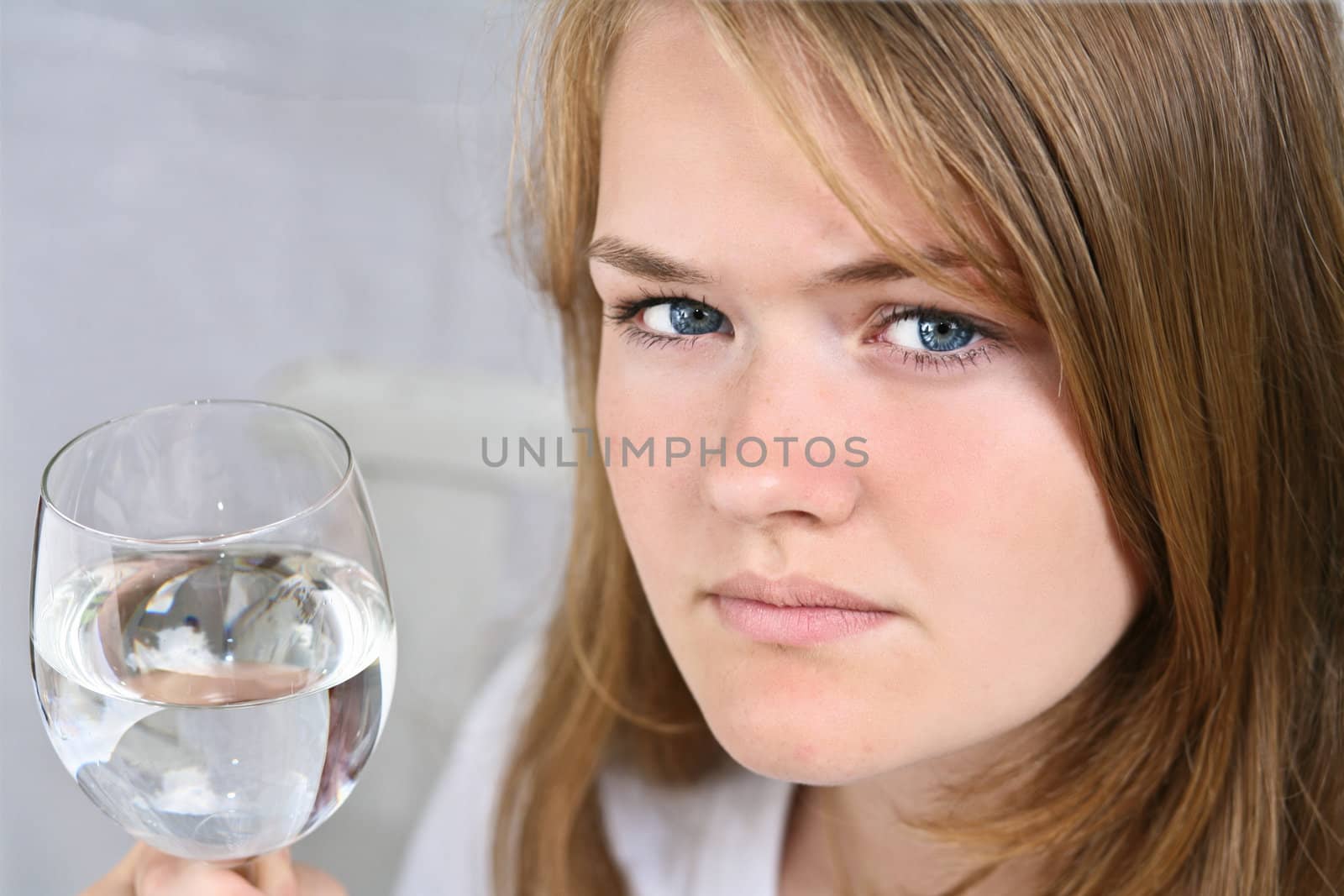 Girl with a glass of water looking at the camera