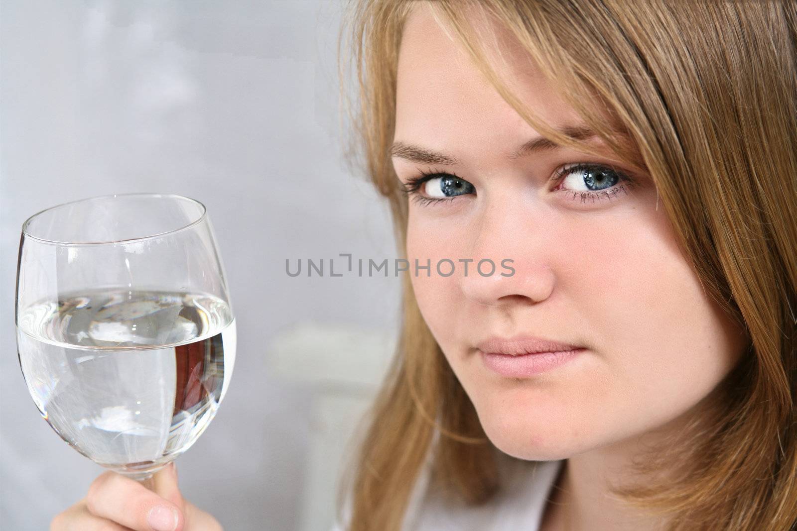 Girl with a glass of water looking at the camera