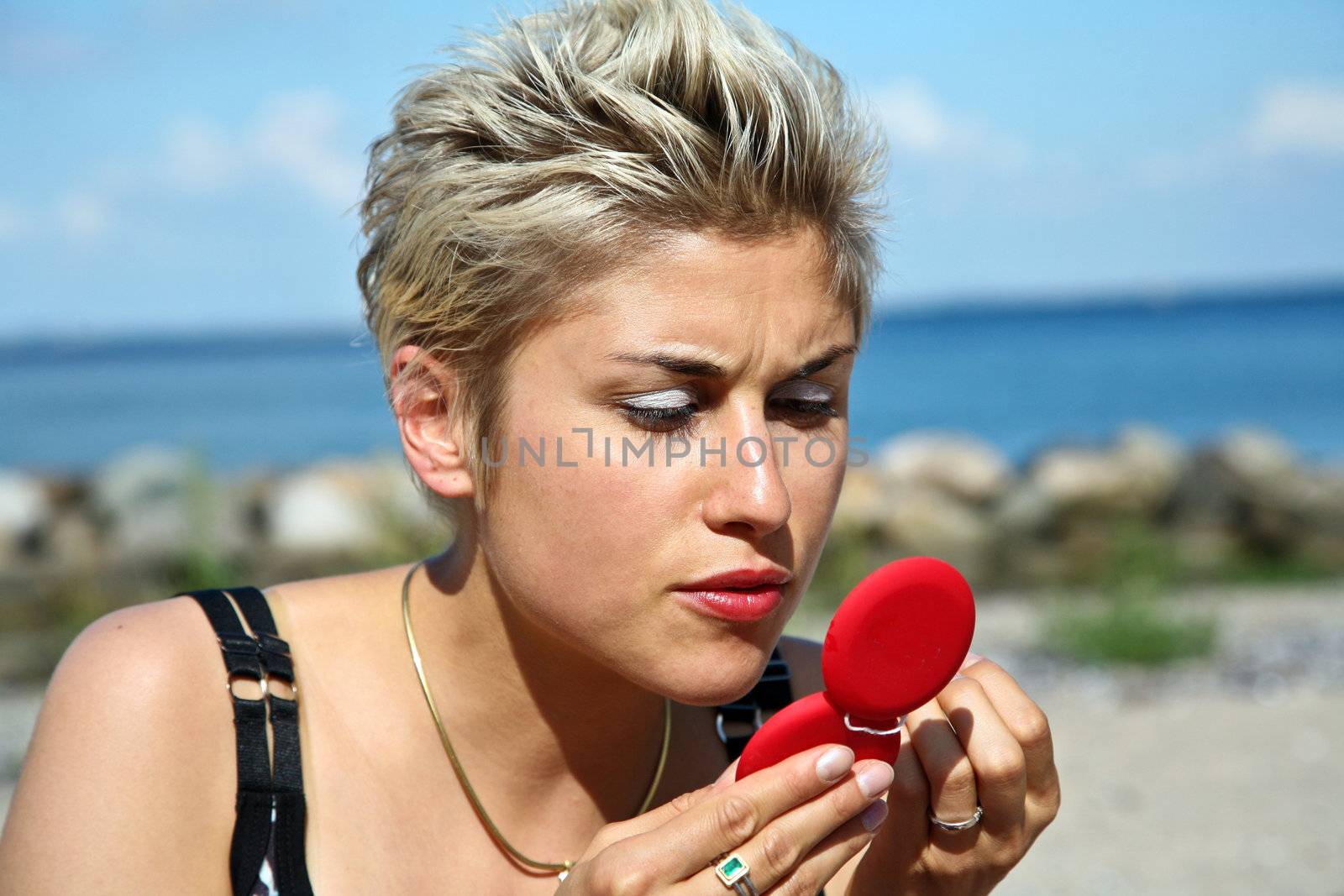 Cute blond girl playing with water in the summer in Denmark