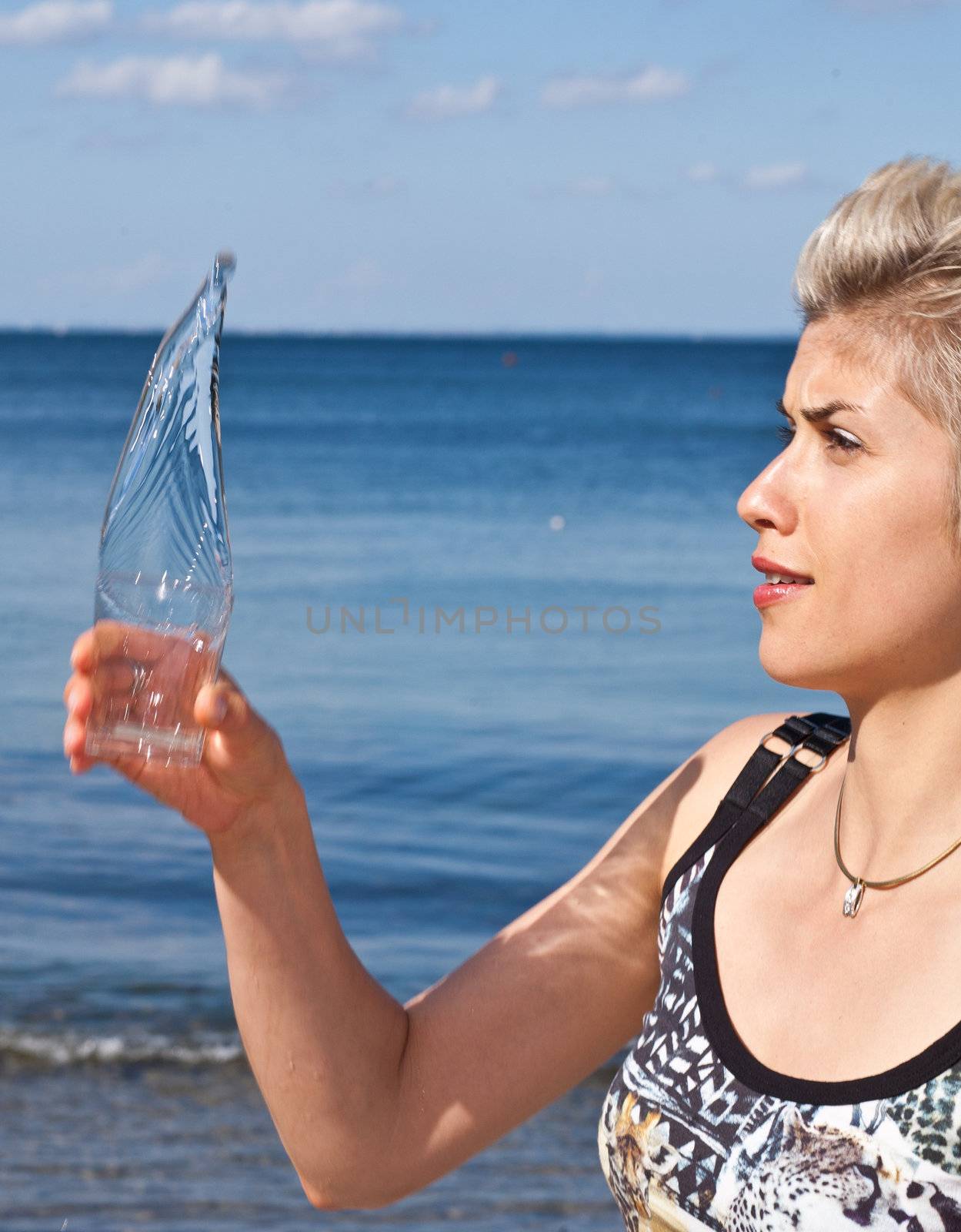 Cute blond girl playing with water in the summer in Denmark