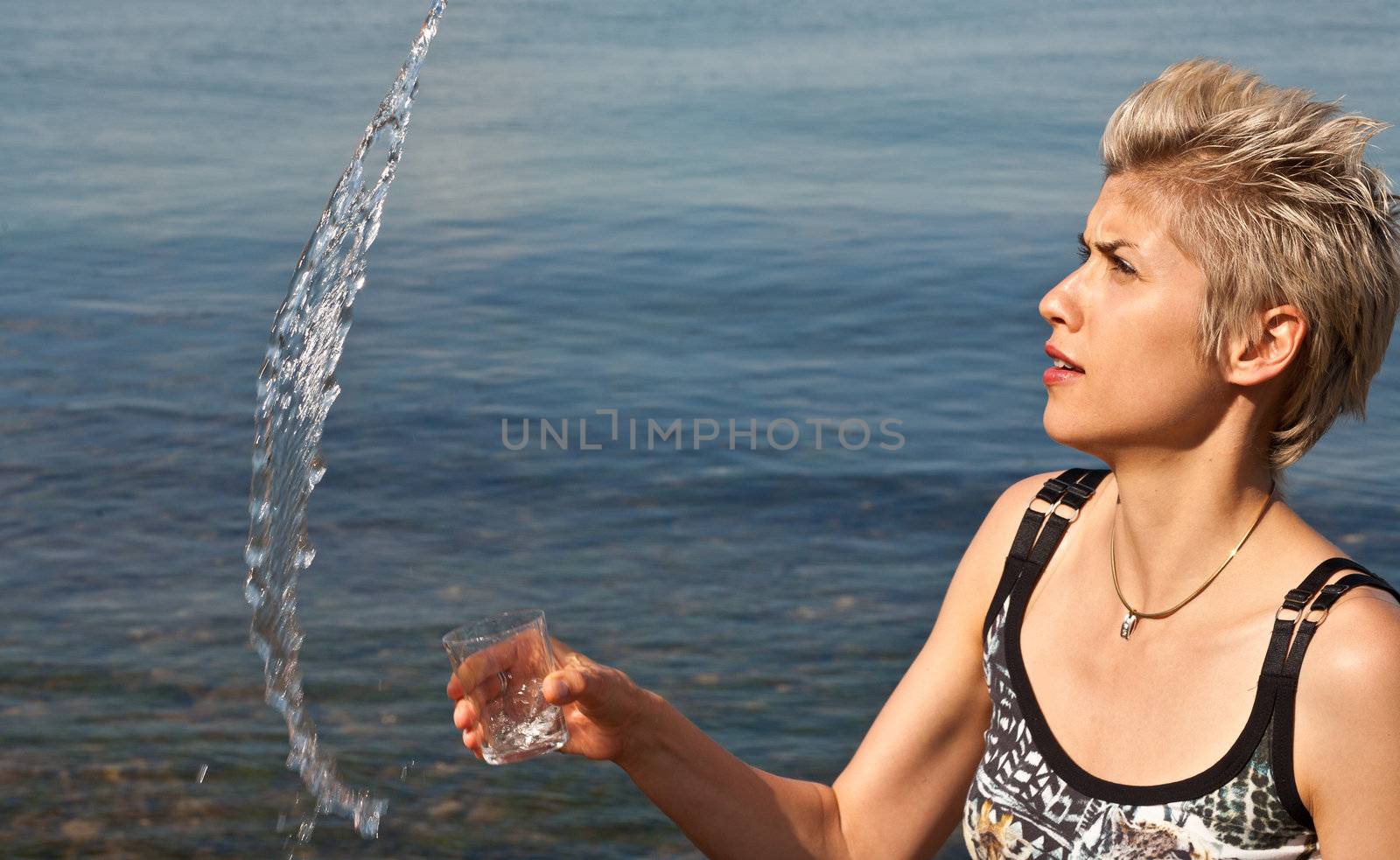 Cute blond girl playing with water in the summer in Denmark